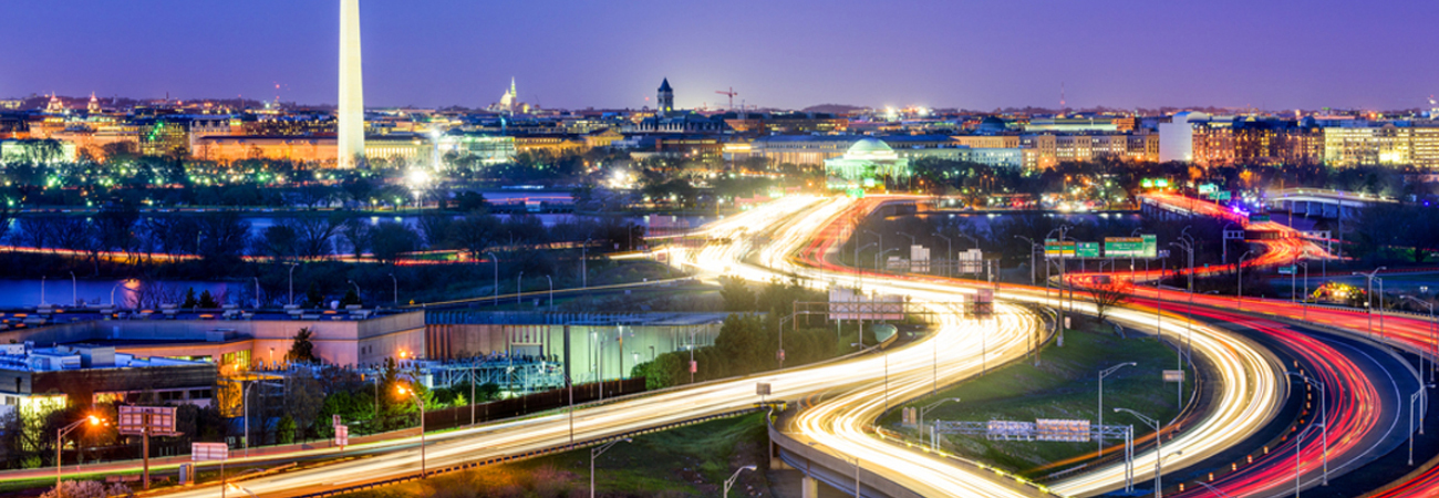 BELLEVUE Moving & Storage – A vibrant cityscape at night with illuminated highways and famous landmarks in the distance.