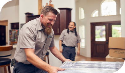 Move Northwest employees carefully wrapping furniture for a Moving & Storage service inside a home.